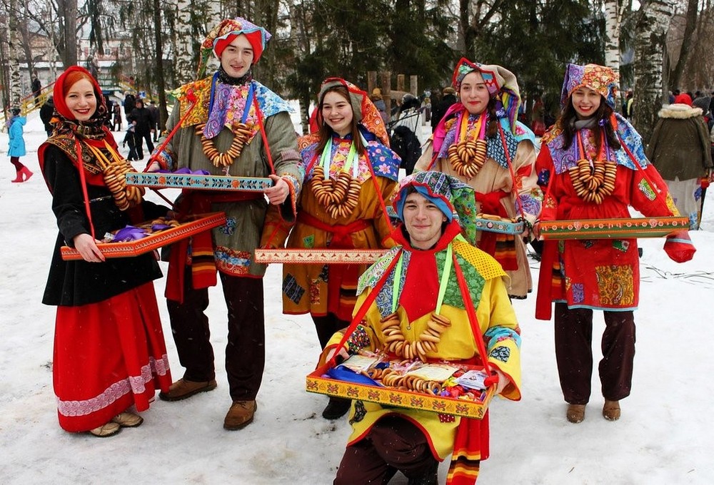 Люди в ошатних костюмах з бубликами та частуванням