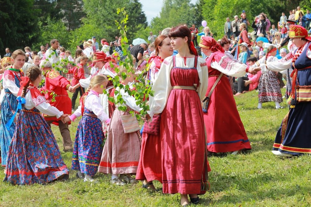 Дорослі та діти в костюмах на полі біля дерев